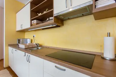 a kitchen with white cabinets and a sink at Apartma Luna in Kranjska Gora