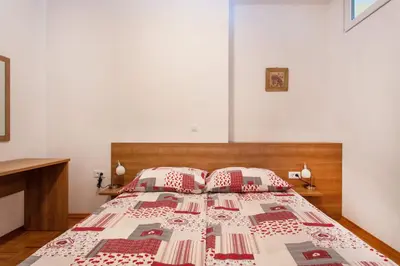a bedroom with a bed with red and white pillows at Apartma Luna in Kranjska Gora