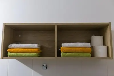 a wooden shelf with towels and toilet paper in a bathroom at Apartma Luna in Kranjska Gora