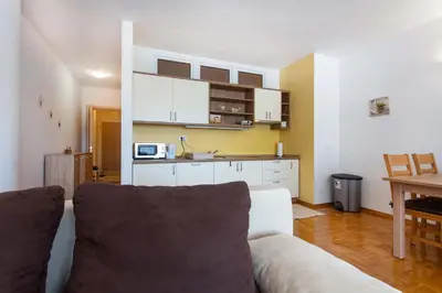 a living room with a white couch and a kitchen at Apartma Luna in Kranjska Gora
