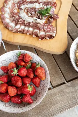 a plate of strawberries next to a plate of food at Holiday Home Virida, app Leopold III in Ivančna Gorica