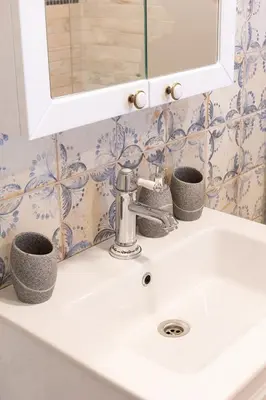a bathroom sink with two cups and a mirror at Holiday Home Virida, app Leopold III in Ivančna Gorica