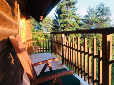 a porch with two rocking chairs on a cabin at Romantic Cottage House in Žužemberk
