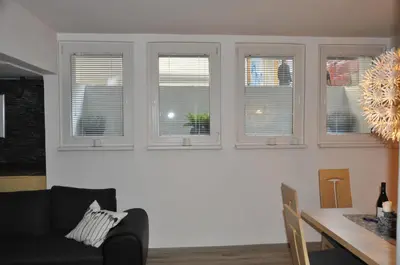 a living room with four windows and a table at Skier's cave in Kranjska Gora