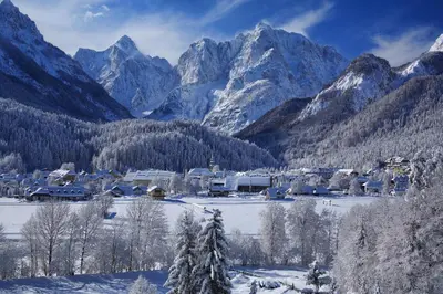 a village in the snow with mountains in the background at Skier's cave in Kranjska Gora