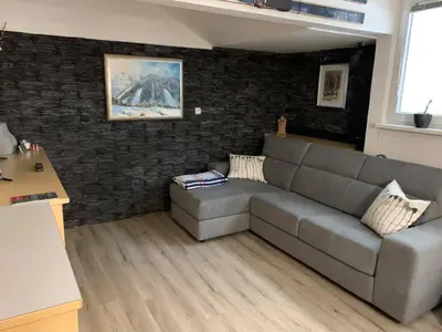 a living room with a couch and a brick wall at Skier's cave in Kranjska Gora