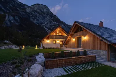 a log home with a mountain in the background at PRIVILLAGE Stare - B&B in Bohinj