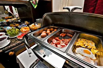 a buffet with eggs and other food on a table at PRIVILLAGE Stare - B&B in Bohinj