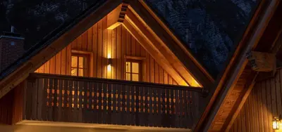 a wooden house with a balcony at night at PRIVILLAGE Stare - B&B in Bohinj