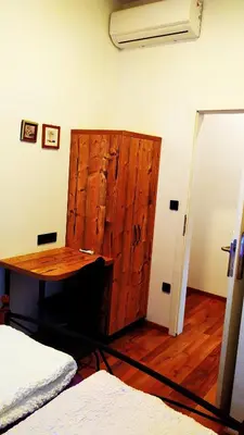 a room with a wooden cabinet and a table at AdHoc Hostel in Ljubljana