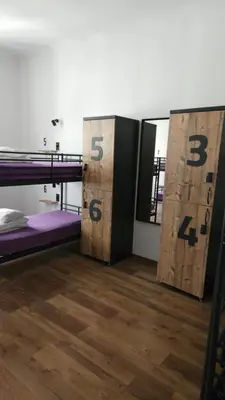 a room with two bunk beds and wooden doors at AdHoc Hostel in Ljubljana