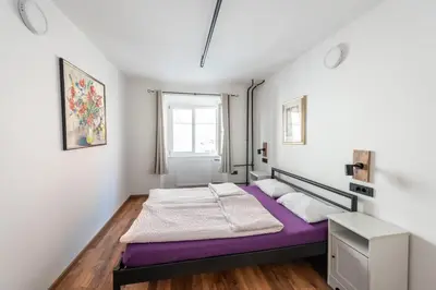 a bedroom with a purple bed and a window at AdHoc Hostel in Ljubljana