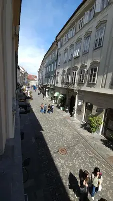 a group of children walking down a street with buildings at AdHoc Hostel in Ljubljana
