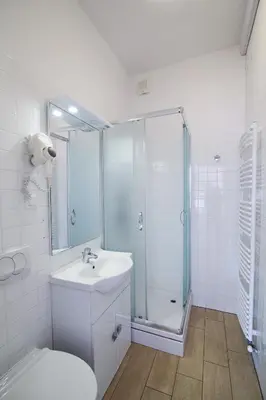 a bathroom with a shower and a sink and a toilet at Hotel Katrca in Ljubljana
