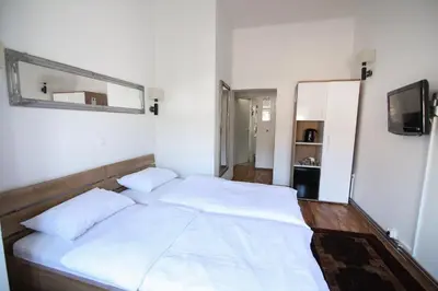 a large white bed in a room with a mirror at Hotel Katrca in Ljubljana