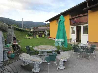 a patio with a table and chairs and an umbrella at TURISTIČNA KMETIJA LIPNIK in Lovrenc na Pohorju
