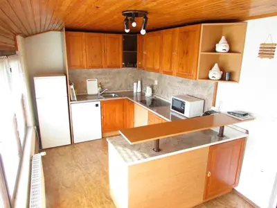 a kitchen with wooden cabinets and a white refrigerator at TURISTIČNA KMETIJA LIPNIK in Lovrenc na Pohorju