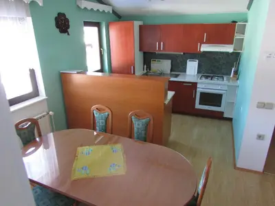 a kitchen with a wooden table and a dining room at TURISTIČNA KMETIJA LIPNIK in Lovrenc na Pohorju