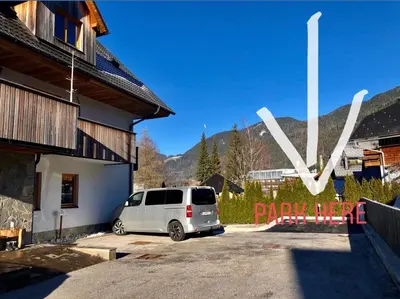a white van parked in a parking lot next to a building at Apartma Lenka Kranjska Gora in Kranjska Gora
