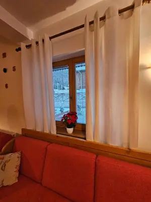 a living room with a red couch and a window at Apartma Lenka Kranjska Gora in Kranjska Gora
