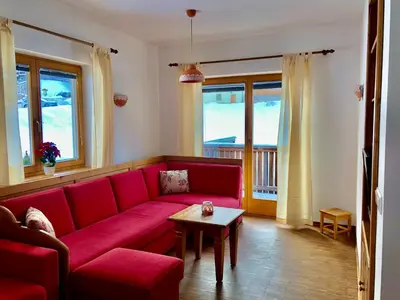 a living room with a red couch and a table at Apartma Lenka Kranjska Gora in Kranjska Gora