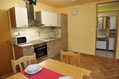 a kitchen with a table and a dining room at apartma Marjetica in Blejska Dobrava