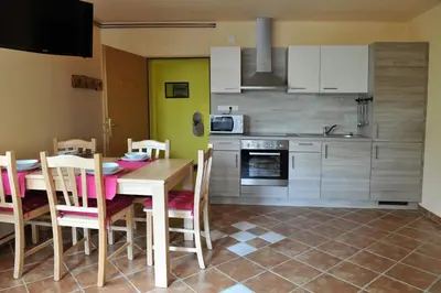 a kitchen and dining room with a table and chairs at apartma Marjetica in Blejska Dobrava