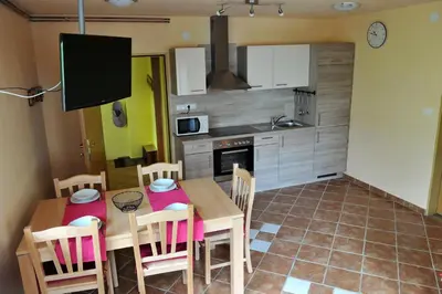 a kitchen and dining room with a table and chairs at apartma Marjetica in Blejska Dobrava