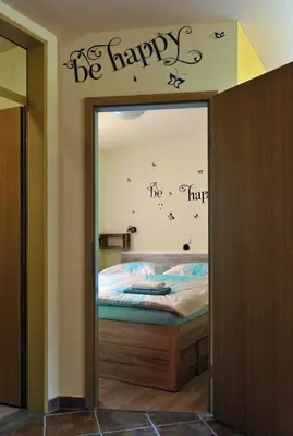 a bedroom with a bed with words on the wall at apartma Marjetica in Blejska Dobrava