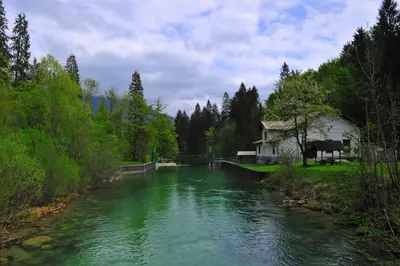 a river with a house on the side of it at apartma Marjetica in Blejska Dobrava