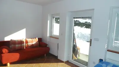 a living room with a red couch and a window at Julija Podkoren in Kranjska Gora