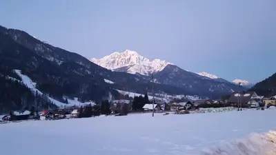 a snow covered field with a mountain in the background at Julija Podkoren in Kranjska Gora