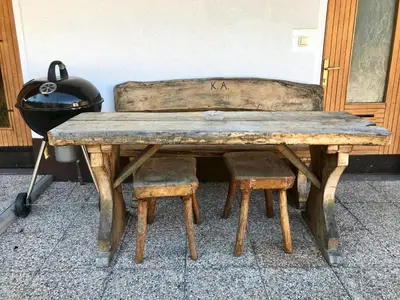 a wooden table with a bench and a stool at Apartma & savna Slapnik in Luče