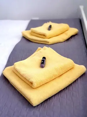 three yellow towels are sitting on a bed at Metelkova in Ljubljana