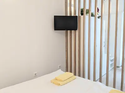 a bedroom with a bed with a tv on the wall at Metelkova in Ljubljana