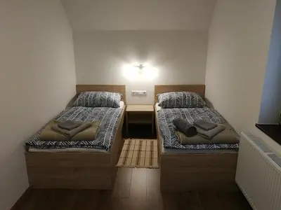 two beds in a small room with a light on the wall at Apartment KLEMEN in Bohinjska Bela