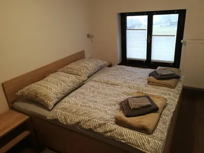 a bed with two pillows on it with a window at Apartment KLEMEN in Bohinjska Bela