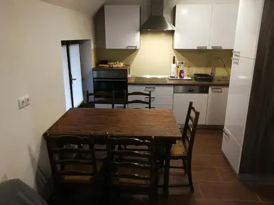 a kitchen with a wooden table and chairs at Apartment KLEMEN in Bohinjska Bela