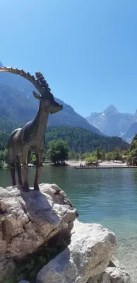 a statue of a giraffe on a rock near water at Nigritella in Kranjska Gora