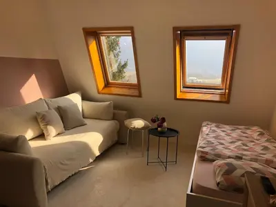 a living room with a couch and two windows at Bovec Apartment in Bovec