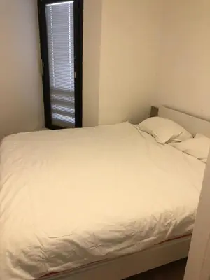 a white bed in a room with a window at Bovec Apartment in Bovec