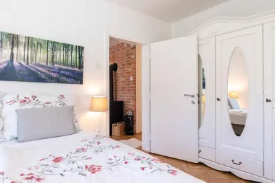 a bedroom with a white bed and a painting on the wall at Apartma Peček Kranjska Gora in Kranjska Gora