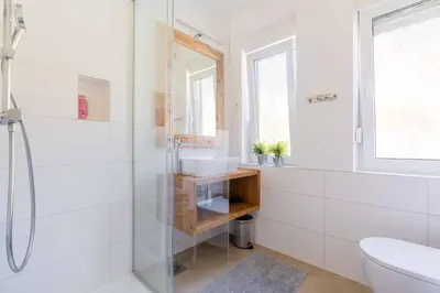 a white bathroom with a sink and a shower at Apartma Peček Kranjska Gora in Kranjska Gora
