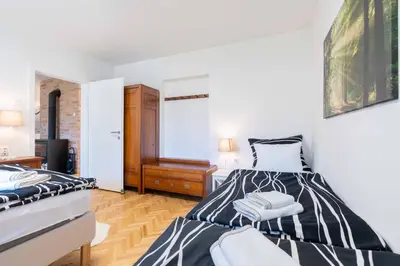 two beds in a room with white walls and wooden floors at Apartma Peček Kranjska Gora in Kranjska Gora