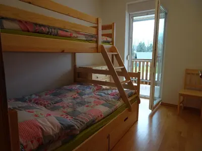 a bedroom with two bunk beds and a balcony at ALPIN apartma in Bovec