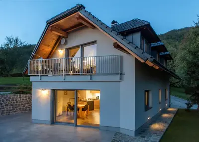 a house with a balcony and a dining room at Apartments Sivka - Private Sauna in Cerklje na Gorenjskem