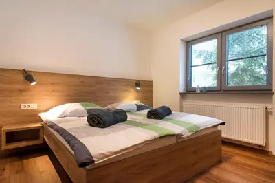 a bedroom with a bed with two pillows on it at Apartments Sivka - Private Sauna in Cerklje na Gorenjskem