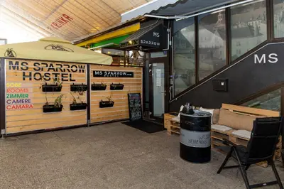 a store front with a table and an umbrella at MS Sparrow Hostel in Ljubljana