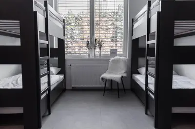 a room with bunk beds with a chair and a window at MS Sparrow Hostel in Ljubljana