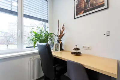 a desk in a room with two chairs and a window at MS Sparrow Hostel in Ljubljana